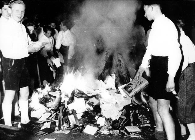 Membros da juventude do Partido Nazista promovem queima de livros censurados. Salzburgo, Áustria, abril de 1938