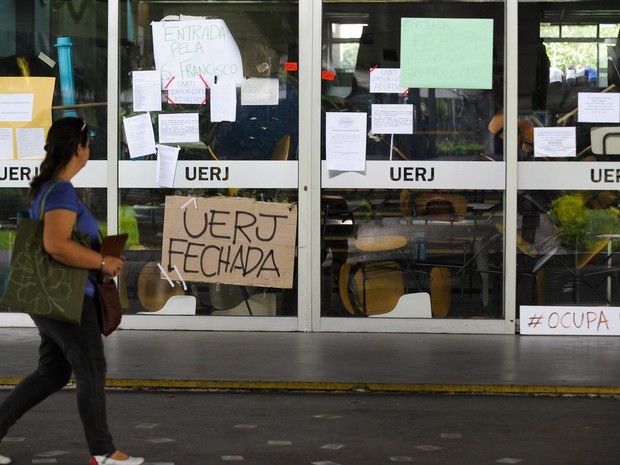 Uma mulher passa por um prédio da Universidade Estadual do Rio de Janeiro durante ocupação de estudantes em 2015. (Foto: Tânia Rego/Agência Brasil)
